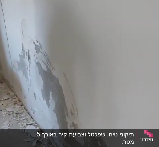 קיר עם טיח מתקלף וחתיכות על הרצפה